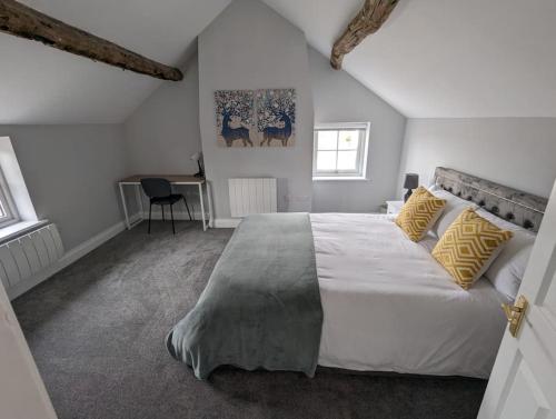 um quarto com uma grande cama branca com almofadas amarelas em 31 High Street - Modern & Stylish 2-bed Apartment - inc parking em Husbands Bosworth
