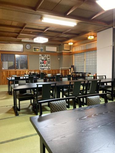 een eetkamer met tafels en stoelen en een klok bij Uchihan in Nozawa Onsen