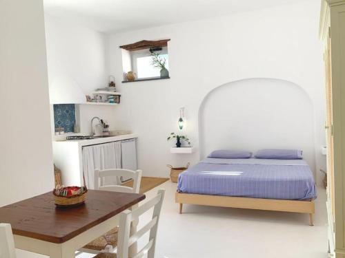 a bedroom with a bed and a table and a kitchen at Agata B&B in Lipari