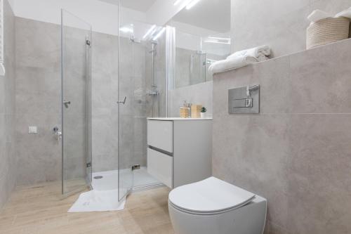 een badkamer met een toilet en een glazen douche bij Apartament Kaszmir by Major Domus Club in Dziwnów