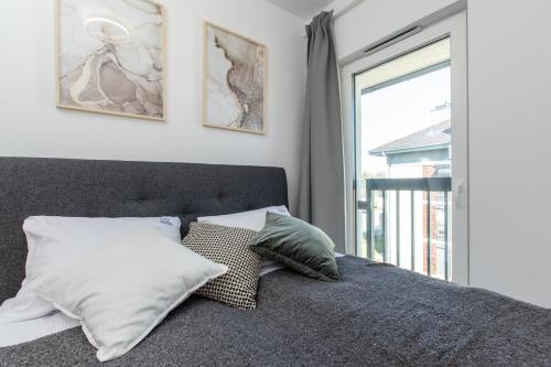 een slaapkamer met een bed met 2 kussens en een raam bij Apartament Kaszmir by Major Domus Club in Dziwnów