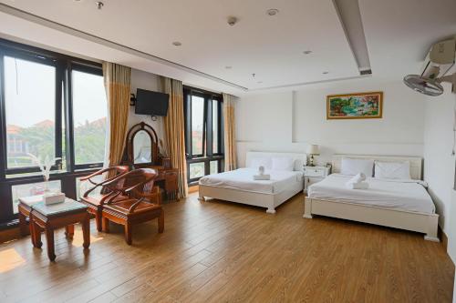 a large room with two beds and a table at SeaColor Beachstay Danang Hotel by Haviland in Da Nang