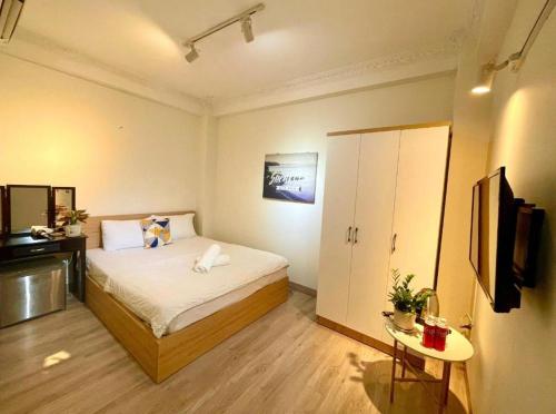 a small bedroom with a bed and a television at Anh Thien Sai Gon Central Hotel - by Bay Luxury in Ho Chi Minh City