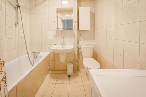 W łazience znajduje się umywalka, toaleta i wanna. w obiekcie Stara Piekarnia - Studio Dworcowa w Olsztynie