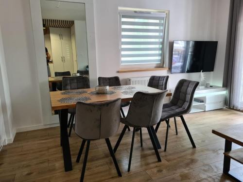 une salle à manger avec une table et des chaises dans l'établissement Apartament w sosnowym lesie, à Międzywodzie