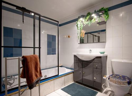 La salle de bains est pourvue d'une baignoire, d'un lavabo et de toilettes. dans l'établissement Appartement T3 70m2 lumineux proche de la gare, à Annecy