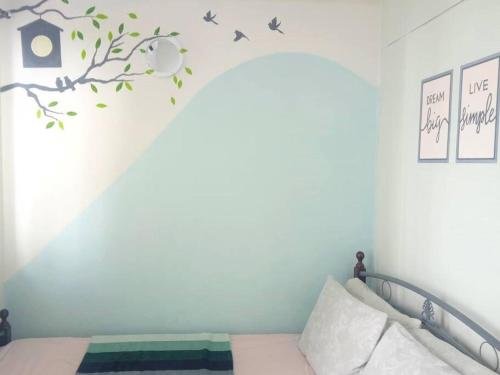 um quarto com uma cama com um galho e pássaros na parede em NEAREST MALL of ASIA Resort-facing 1BR fast wifi em Manila