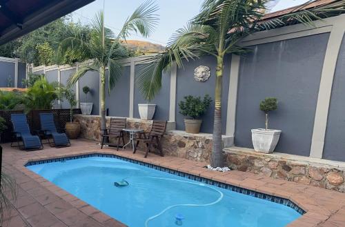 a swimming pool in a patio with a table and chairs at Luxury and Comfort Hideaway 1 - Solar Powered in Pretoria