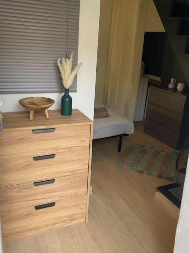 Cette chambre comprend une commode en bois et un lit. dans l'établissement Maison de village située à 10 mins d'Ajaccio, à Alata