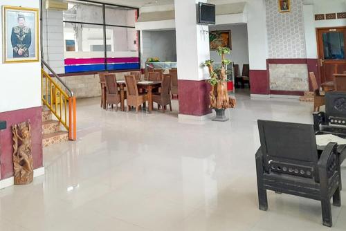 a room with a table and chairs and a piano at Urbanview Hotel Istana Bangun Jagad Indramayu by RedDoorz in Indramayu