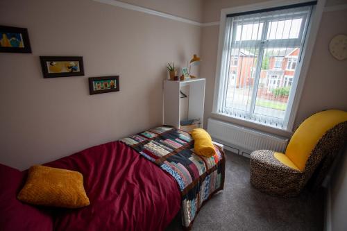 um quarto com uma cama, uma cadeira e uma janela em Quiet residence close to M6 Preston em Samlesbury