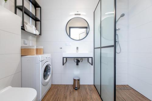a bathroom with a washing machine and a sink at Apartament Classic Spa&Wellness by Major Domus Club in Dziwnów