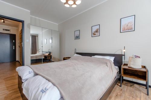 a bedroom with a large bed and a mirror at Apartament Classic Spa&Wellness by Major Domus Club in Dziwnów