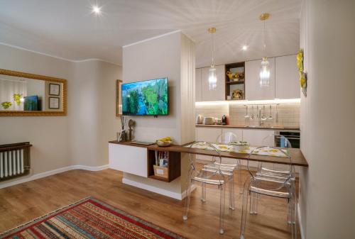 cocina con barra con taburetes y TV en Charming stay in Roma - Luxury Holiday Apartment, en Roma