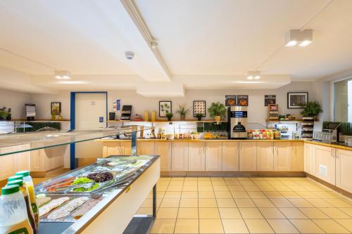 a large kitchen with a lot of food on the counters at a&o Dortmund Hauptbahnhof in Dortmund