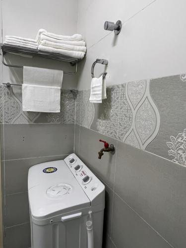 a small bathroom with a white stove and towels at شقة الفخامة in Sharīyah