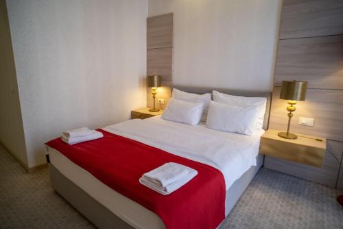 a hotel room with a bed with two towels on it at Hotel Atina in Budva