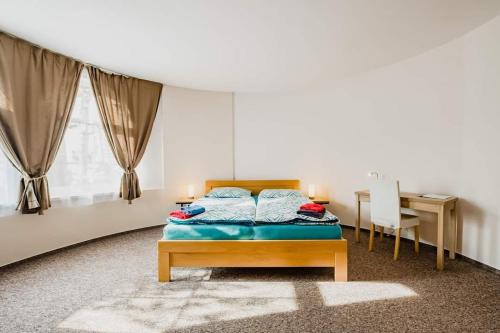 sypialnia z łóżkiem, stołem i biurkiem w obiekcie Motel Vega w mieście Sezimovo Ústí