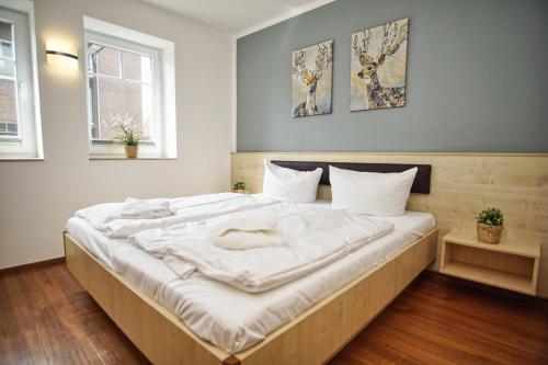 a bedroom with a large bed with white sheets at hafennahe Ferienwohnung mit Meerblick - Hafenresidenz Lauterbach FeWo 2-3 in Lauterbach