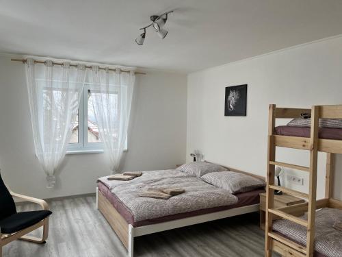 a bedroom with a bed and a ladder and a window at Kozákov Apartmány - druhé patro 