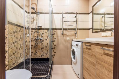 ein Bad mit einer Dusche und einer Waschmaschine in der Unterkunft Baltikalnio apartamentai Klaipėdos centre! in Klaipėda