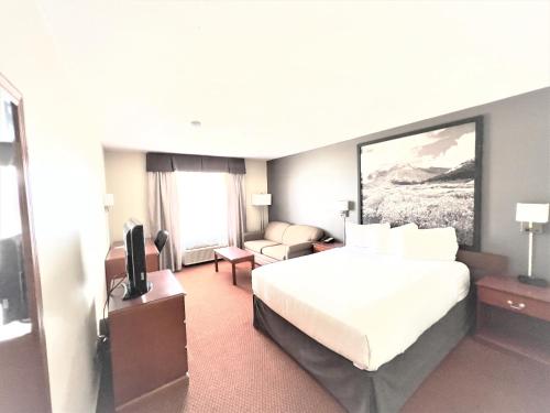 a hotel room with a bed and a television at Super 8 by Wyndham Whitecourt in Whitecourt