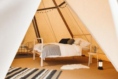 a bedroom with a bed in a tent at GreenWood Family Park in Y Felinheli