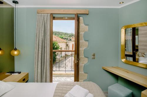 um quarto com uma cama, um espelho e uma janela em Alonion Apartments em Yerakianá