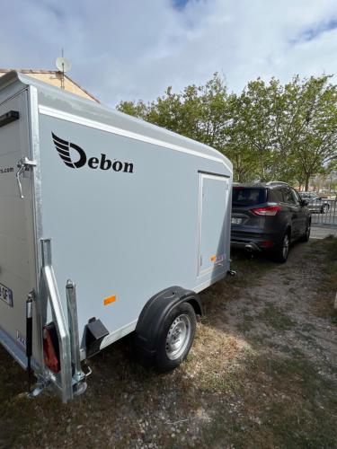 a white trailer is parked next to a car at Petite maison à 100m de la plage in Marseillan