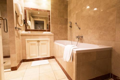 uma casa de banho com uma banheira, um chuveiro e um lavatório. em Boutique Hotel De Doelen em Groningen