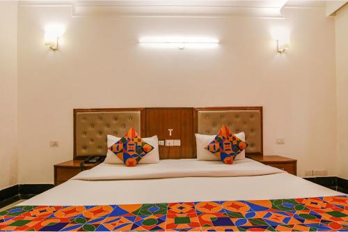 um quarto com uma cama grande e almofadas coloridas em FabExpress JDM Residency em Gurgaon