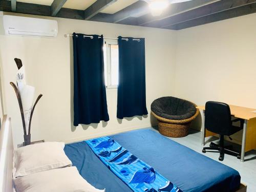 a bedroom with a bed and a desk and curtains at Le Dodo Salé in Étang-Salé