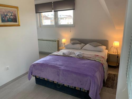 a bedroom with a large bed with a purple blanket at Bed & Breakfast Đurđan in Krapinske Toplice