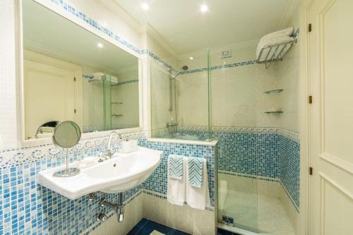 a blue tiled bathroom with a sink and a shower at Céntrico dúplex de lujo en Vigo. in Vigo