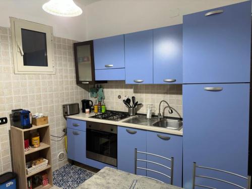 een keuken met blauwe kasten en een wastafel bij Casa vacanze (Totò e Pompilia) in Campi Salentina