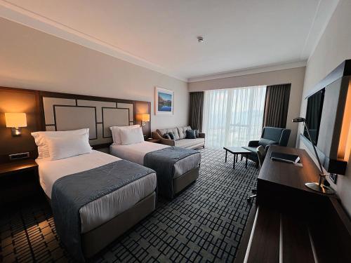 a hotel room with two beds and a flat screen tv at Ramada Plaza by Wyndham Rize in Rize