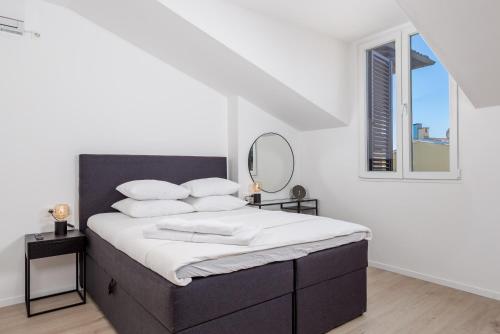 a bedroom with a bed with a mirror and a window at Apartment Pearl, Opatija center in Opatija
