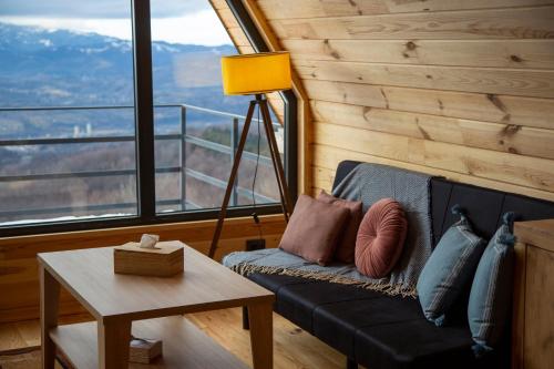 a living room with a couch and a table at Cez A-Frame in Petroşani