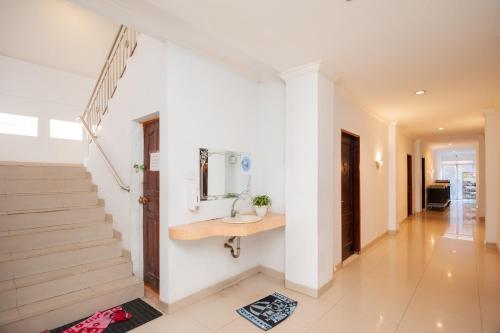 a hallway of a house with a sink and stairs at RedDoorz Syariah near RS Yos Sudarso Padang in Padang