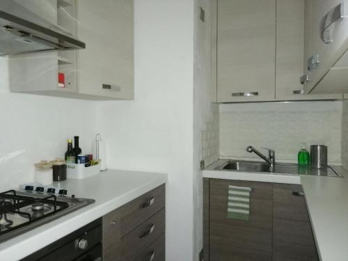 uma cozinha branca com um lavatório e um fogão em Casetta con terrazza em Como