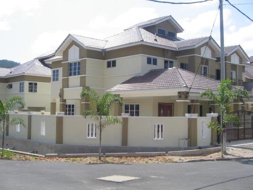 uma casa grande com uma cerca em frente em Greenleaf Angsana Homestay em Jerantut