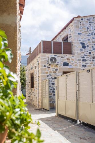 a stone house with a fence in front of a building at Piedra Residence in Pigi