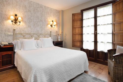 1 dormitorio con cama blanca y ventana en Hotel Rural Casona de Cefontes, en Cefontes