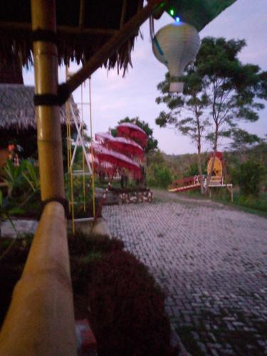 Duren Petruk Twbm Rumpin في Sawah: شارع مرصوف بالحصى مع ملعب ومبنى