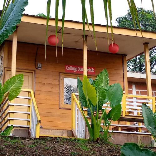 Una casa con un cartel en el costado. en Duren Petruk Twbm Rumpin en Sawah