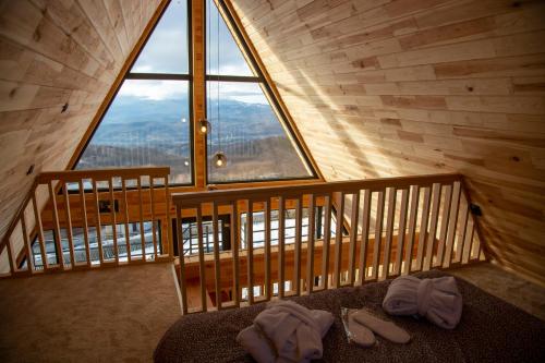 a room with a large window and two pairs of shoes at Cez A-Frame in Petroşani