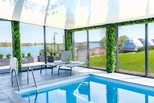 a house with a swimming pool with a view of the water at NGlamping in Chełmża