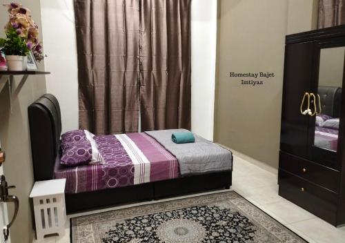 um pequeno quarto com uma cama e uma cómoda em Homestay Bajet Imtiyaz, Terengganu em Bukit Payong