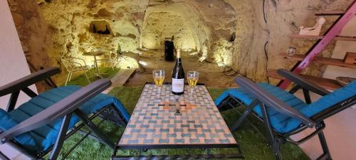 a table with a bottle of wine and some chairs at La Petite Lucette in Amboise