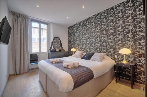 - une chambre avec un grand lit et un mur noir et blanc dans l'établissement MODERNE 3 PIECES IDEALEMENT SITUE CENTRE DE CANNES l! A2B22, à Cannes